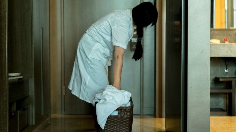 Una mujer limpiando una habitación de hotel