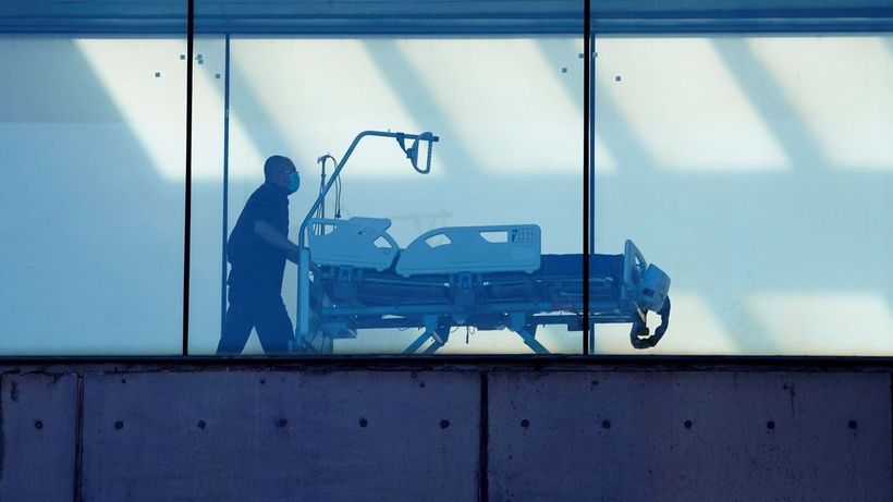 Un celador llevando una camilla