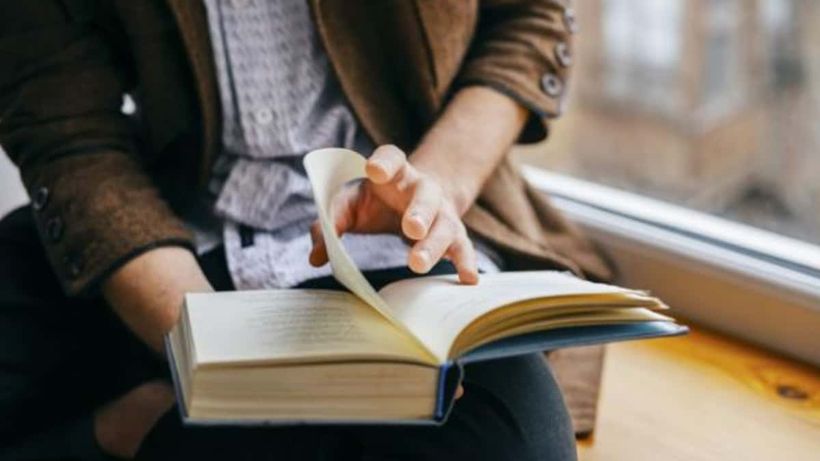 Una persona lee un libro grande