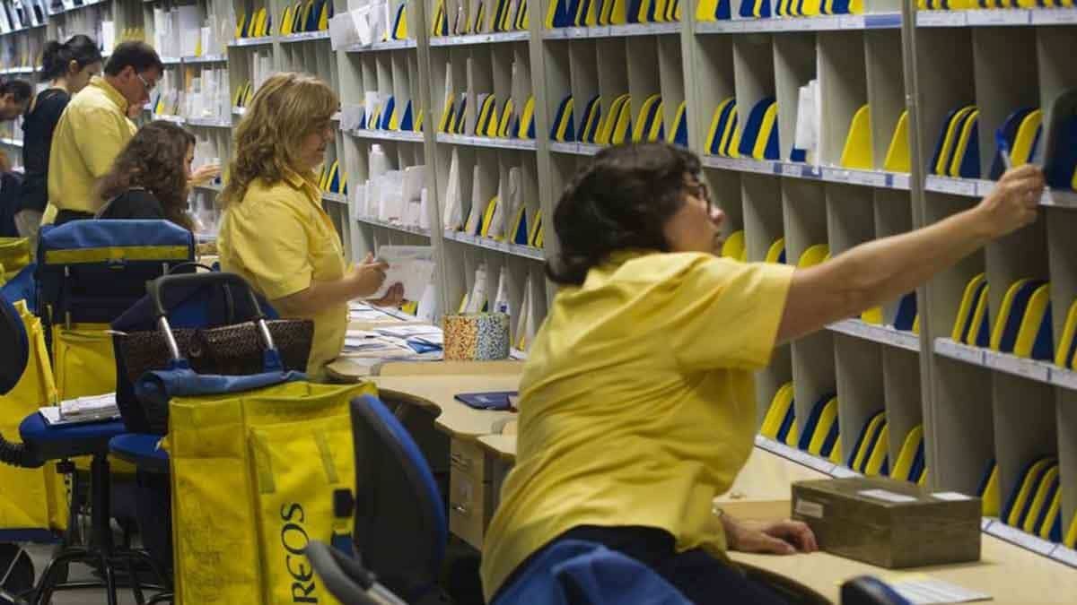 Varios empleados de Correos trabajando Varios empleados de Correos trabajando