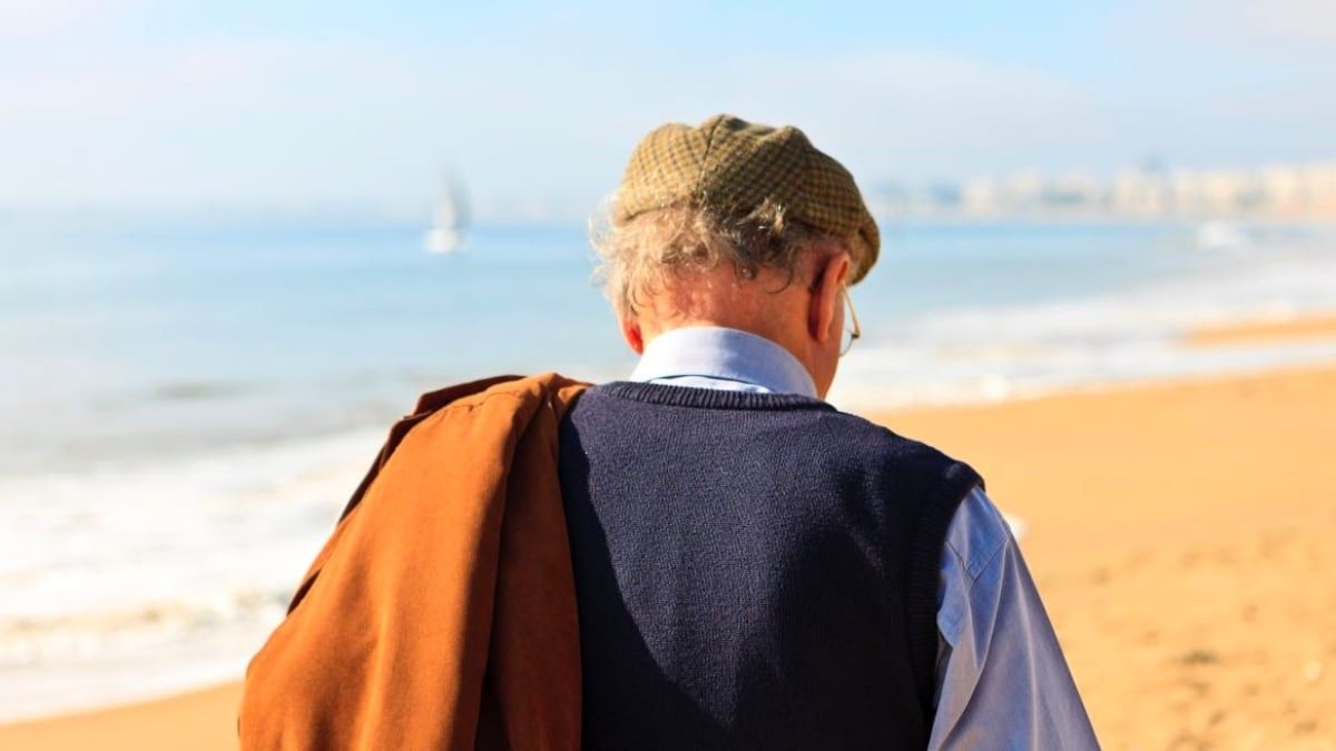 Un pensionista paseando por la playa