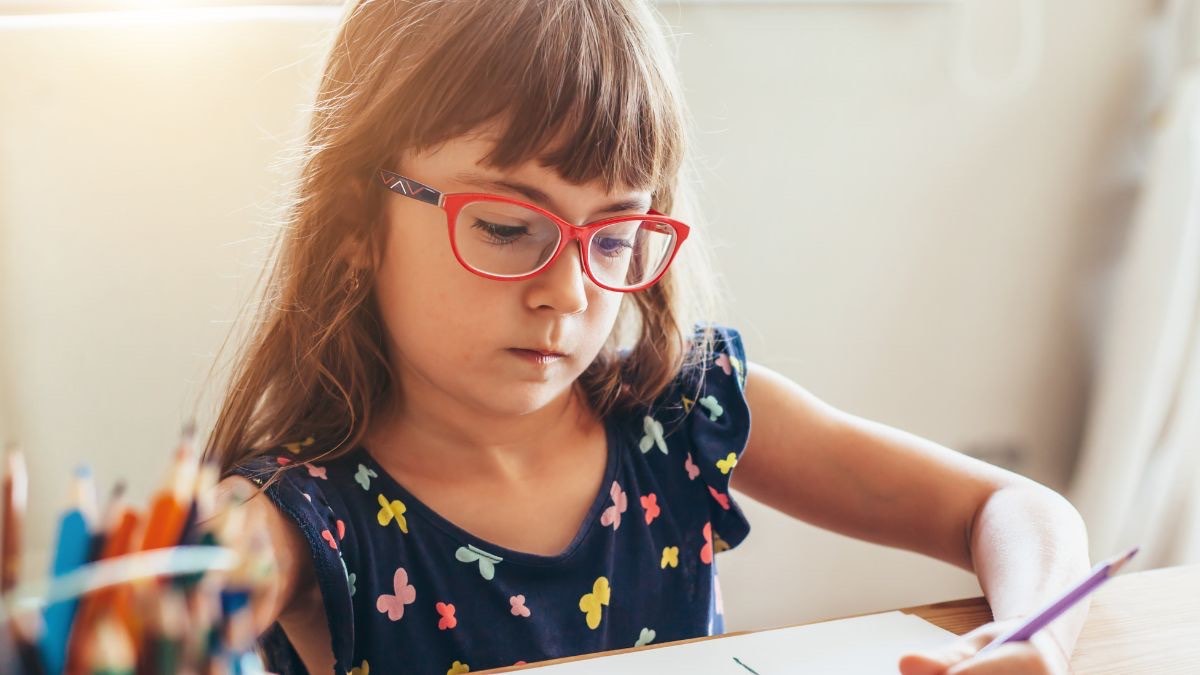 niña con gafas escribiendo