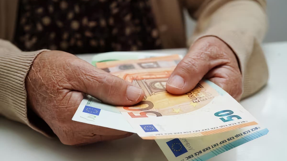 Mujer pensionista sujetando euros en la mano