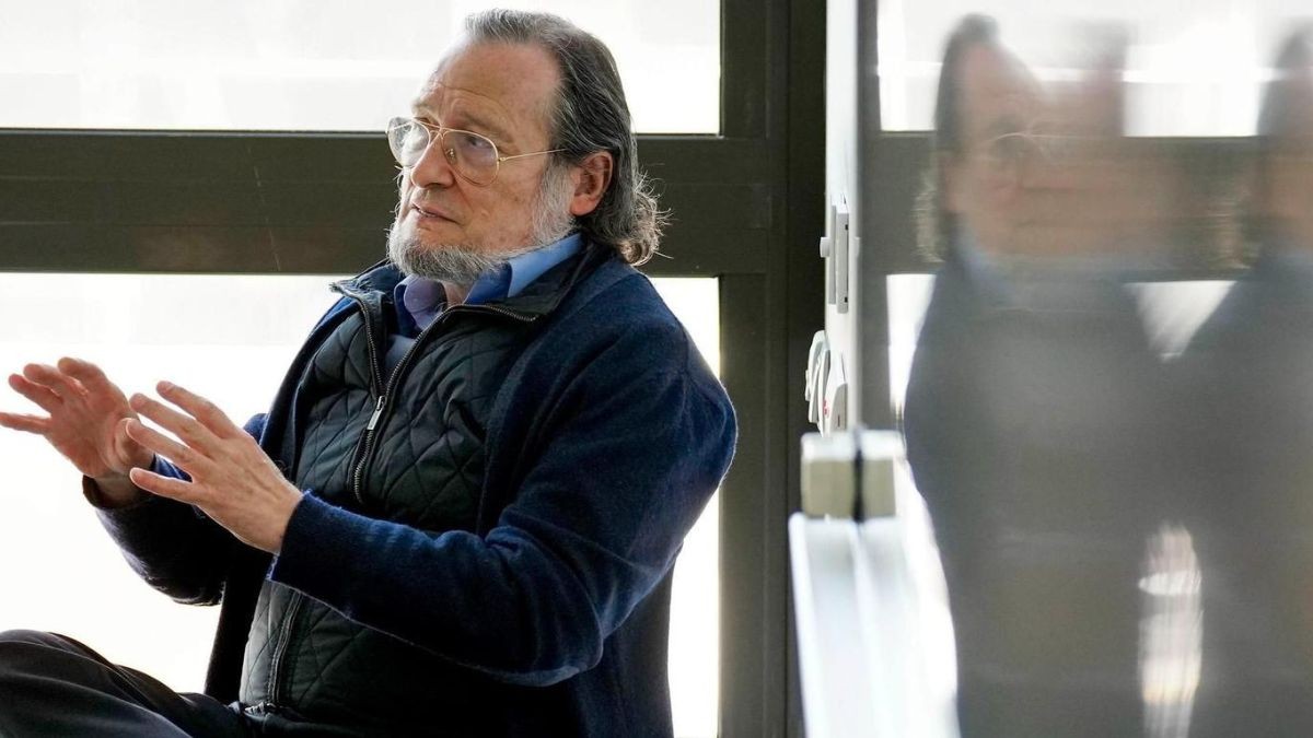 El economista Niño Becerra explica delante de una pizarra blanca.