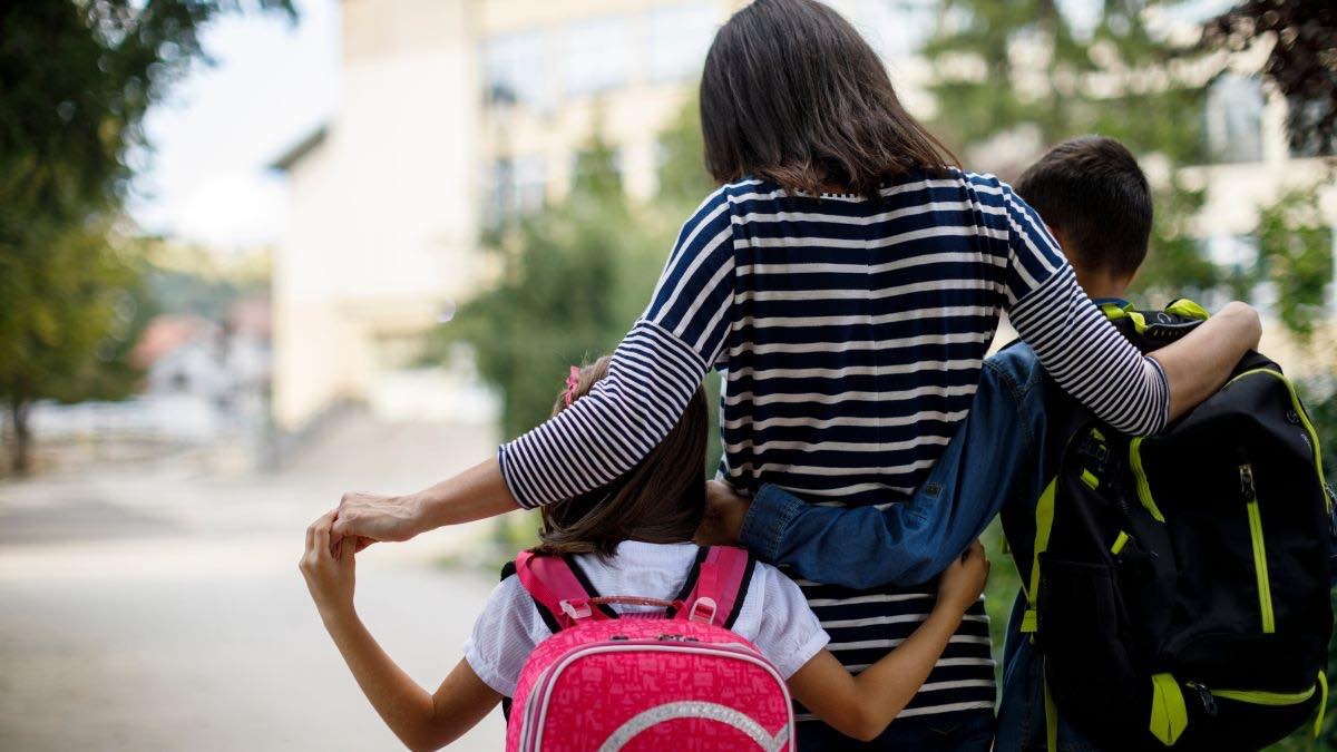 Bruselas inicia el expediente sancionador contra España por el permiso parental. Una madre llevando a sus dos hijos al colegio