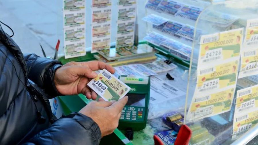 Las manos de una persona sosteniendo un décimo de la ONCE Un vendedor de la ONCE sostiene un décimo