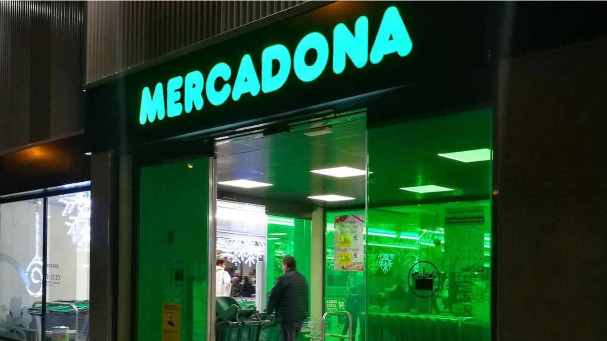 Un supermercado de Mercadona, de noche, con clientes entrando.
