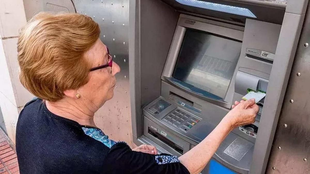 Mujer mayor mayor sacando dinero de un cajero automático Mujer mayor mayor sacando dinero de un cajero automático