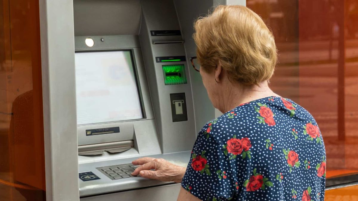 Una jubilada sacando dinero de su pensión de un cajero automático