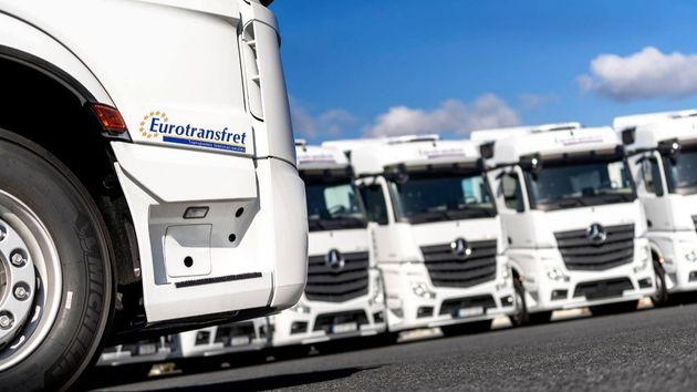 Varios camiones de la empresa Eurotransfet aparcados en un parking.
