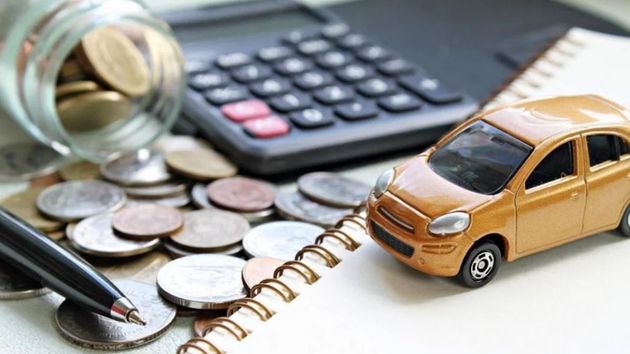 Coche de juguete en una mesa junto con dinero y una calculadora.