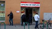Varias personas en frente de una oficina de empleo