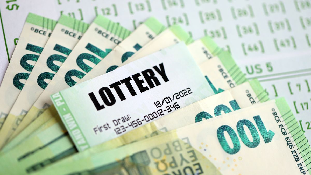 Boleto de lotería junto a billetes de 100 euros