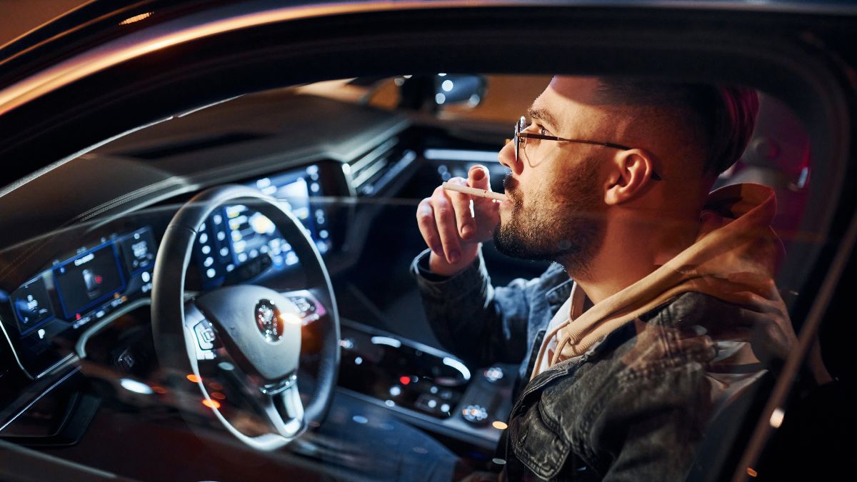 Persona fumando dentro del coche Persona fumando dentro del coche