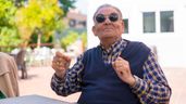 Un jubilado sonriente sentado en un patio