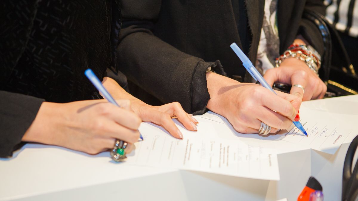 Personas firmando un documento 