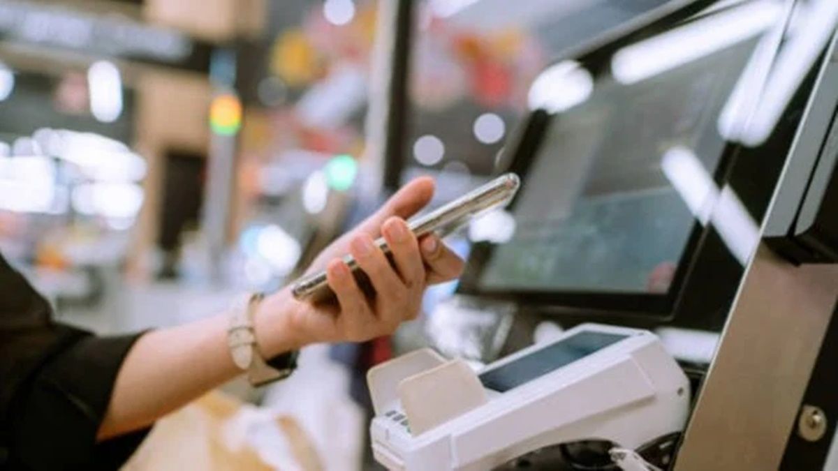 Una clienta usa una caja autopago en un supermercado. Autopago