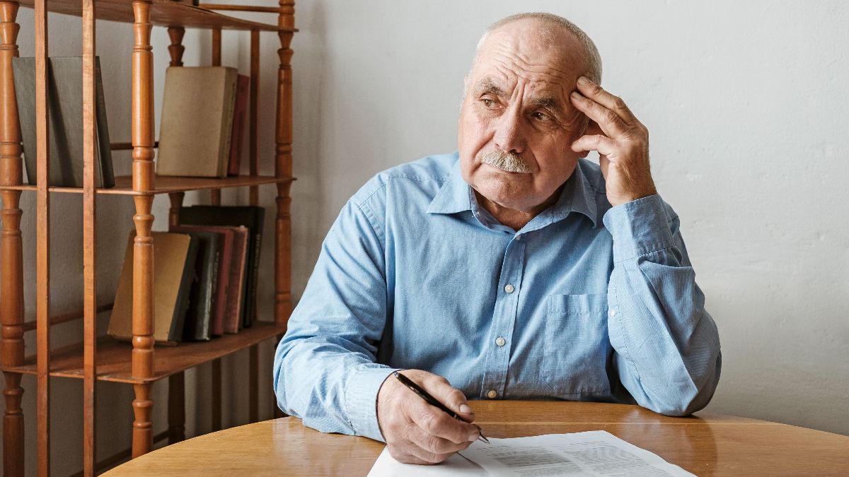 Un anciano firmando un documento Un anciano firmando un documento