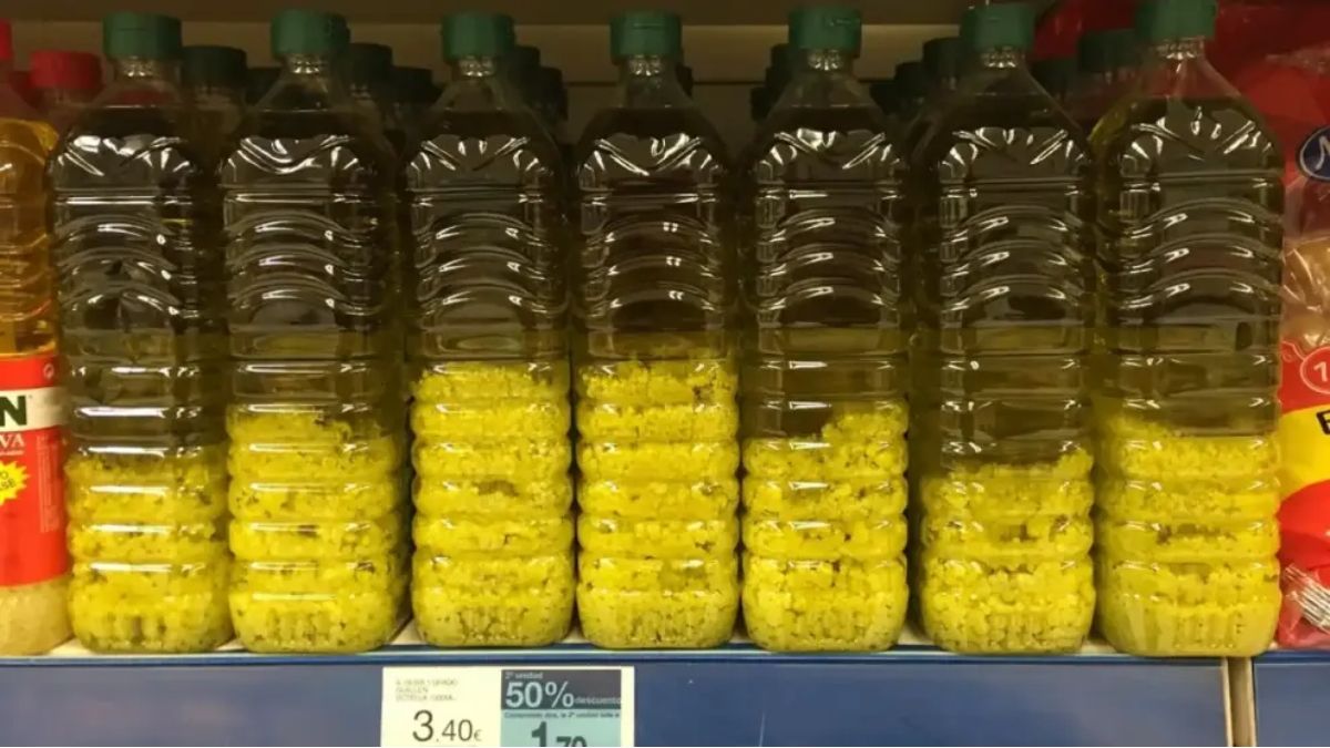 Botellas con aceite de oliva y grumos en el lineal de un supermercado. Aceite de oliva con grumos