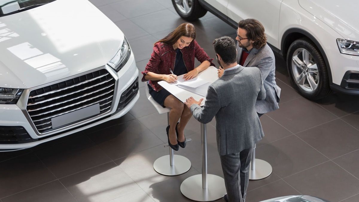 Personas comprando un coche en un concesionario