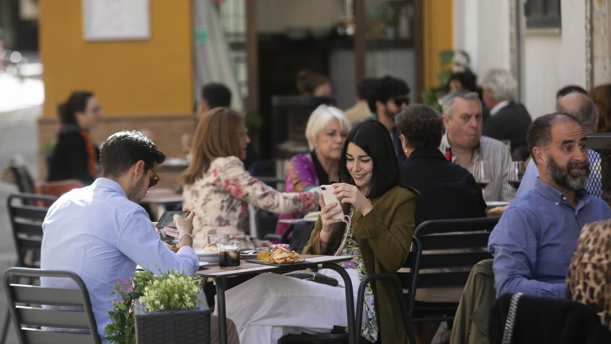 Las personas Gente en un restaurante mirando su teléfono móvil. Restaurante terraza
