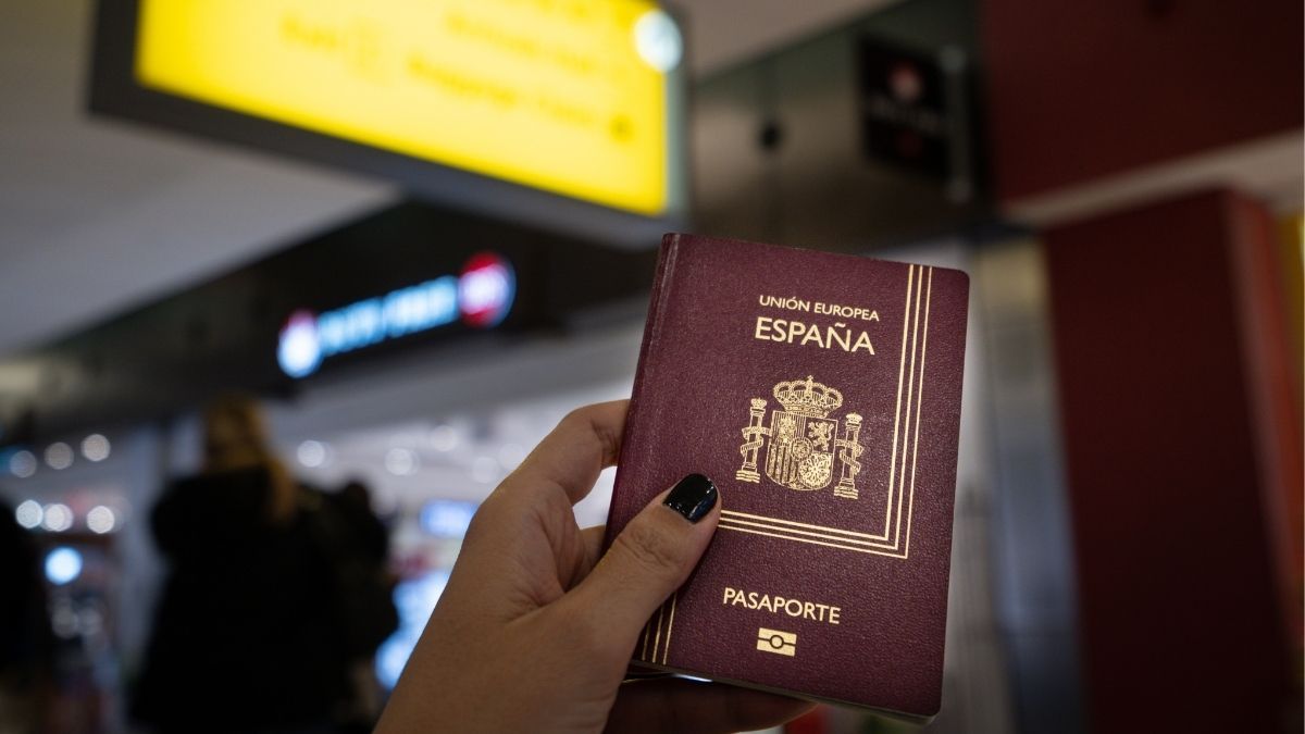 Pasaporte español en la mano de un viajero Pasaporte español en la mano de un viajero