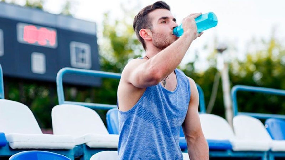 Un deportista bebiendo agua en un entrenamiento. Deportista
