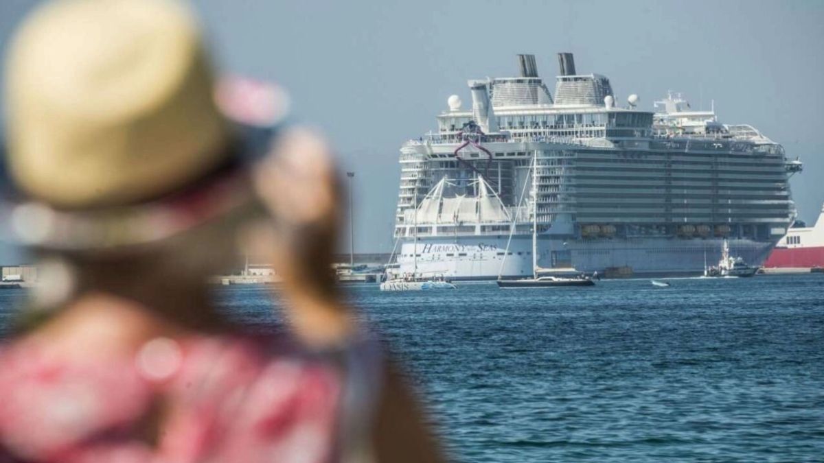 Una mujer mira un barco de crucero con unos prismáticos. Mujer mirando barco