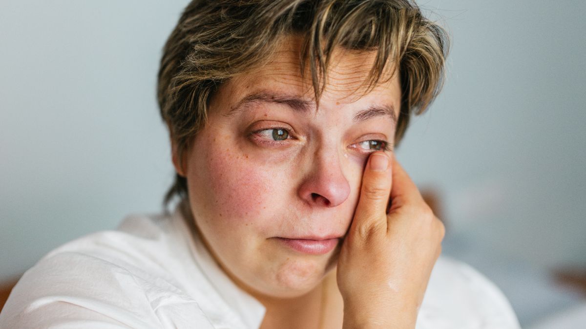 Mujer llorando en el sofá de su casa. Mujer triste