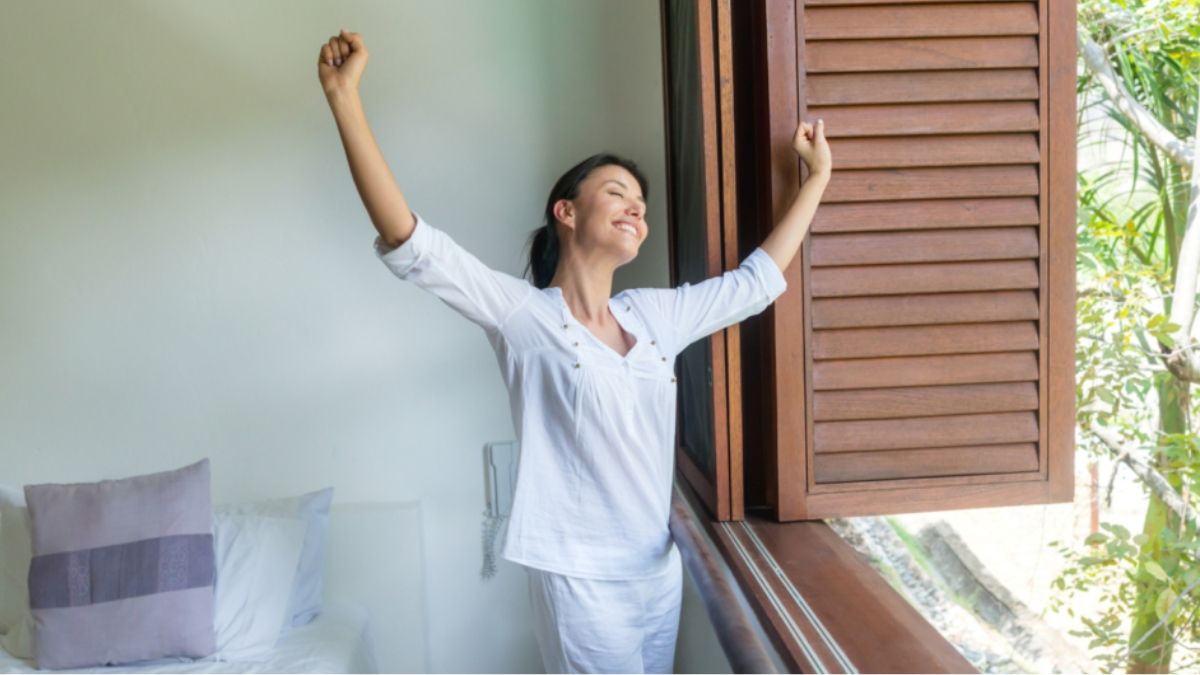 Mujer despertándose al lado de una ventana. Mujer despertando