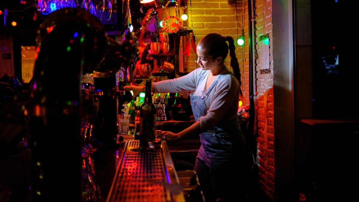 Una camarera trabajando en la barra de un bar. camarera trabajando