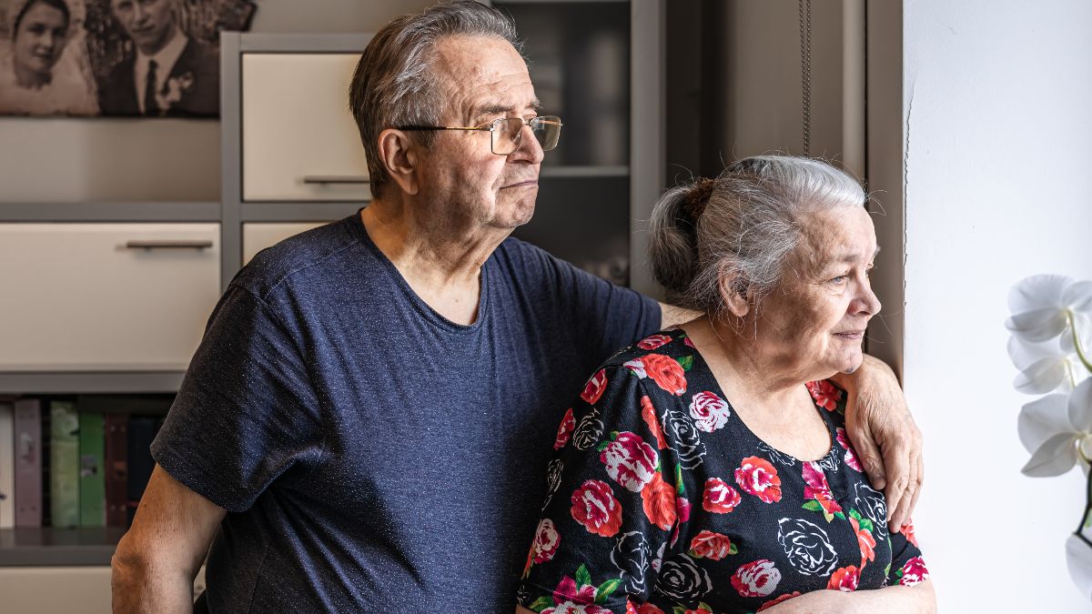 Una pareja de jubilados, mirando por la ventana Una pareja de jubilados, mirando por la ventana