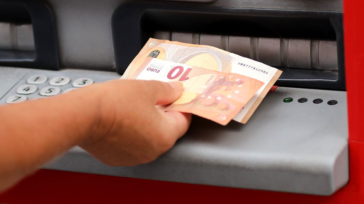 Mano sacando dinero de un cajero automático. Dinero en un cajero automático