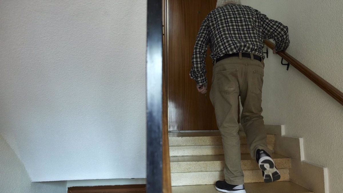 Una persona mayor sube las escaleras de su casa. Persona mayor subiendo escaleras
