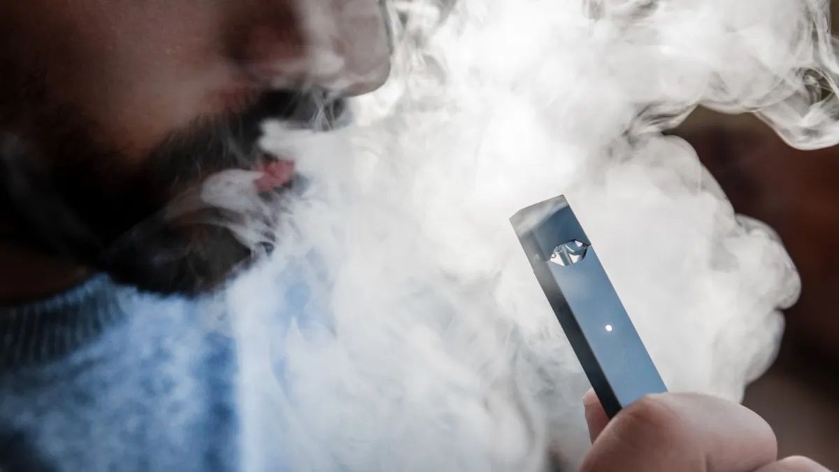 Una persona fumando un cigarrillo electrónico Una persona fumando un cigarrillo electrónico