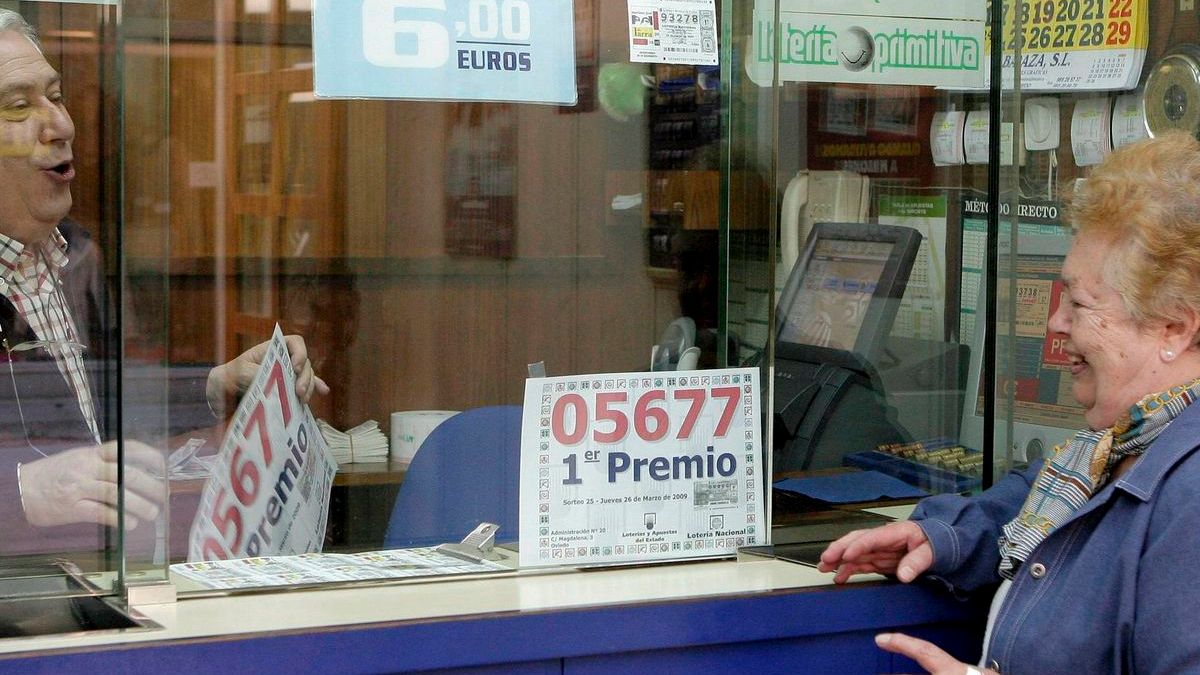 Una mujer comprando lotería en una administración Una mujer comprando lotería en una administración