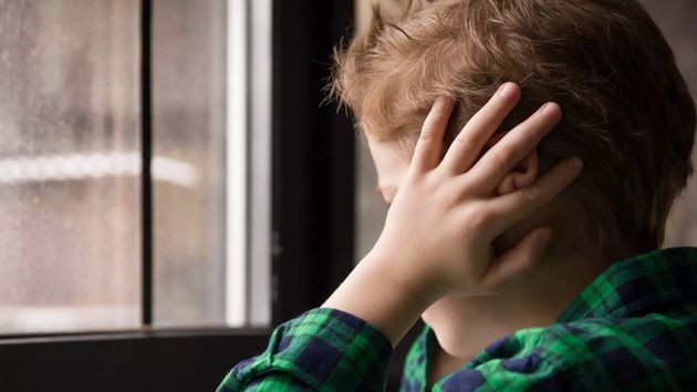Niño con las manos en la cabeza