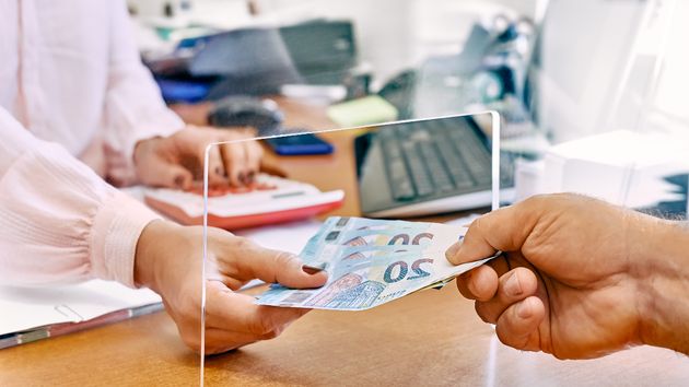 Las manos de una trabajadora recibiendo dinero 