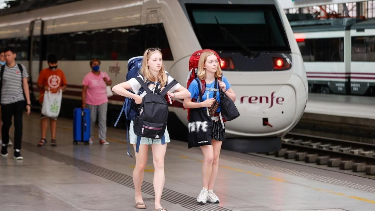 Dos chicas en la estación de trenes Dos chicas comprando un abono de Cercanías en una estación
