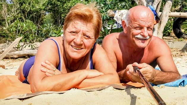 Dos personas mayores tomando el sol en la playa