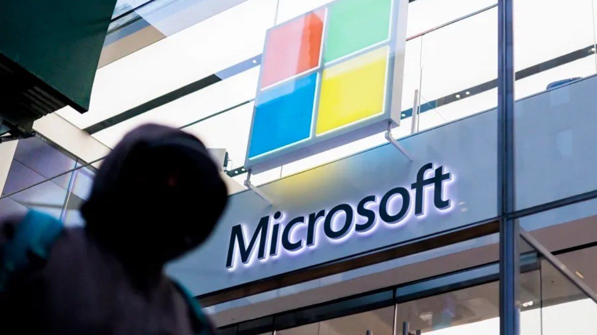 Una persona pasando por la oficina de Microsoft Una persona pasando por la oficina de Microsoft
