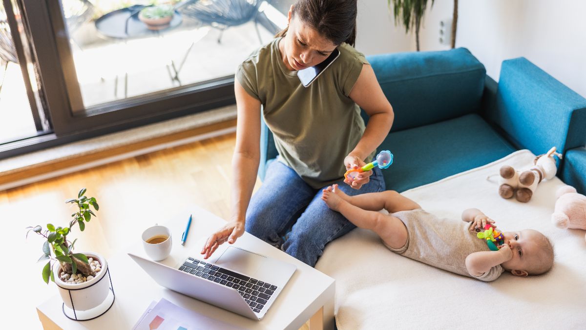 Una madre trabajando mientras cuida de su bebé Una madre trabajando mientras cuida de su bebé
