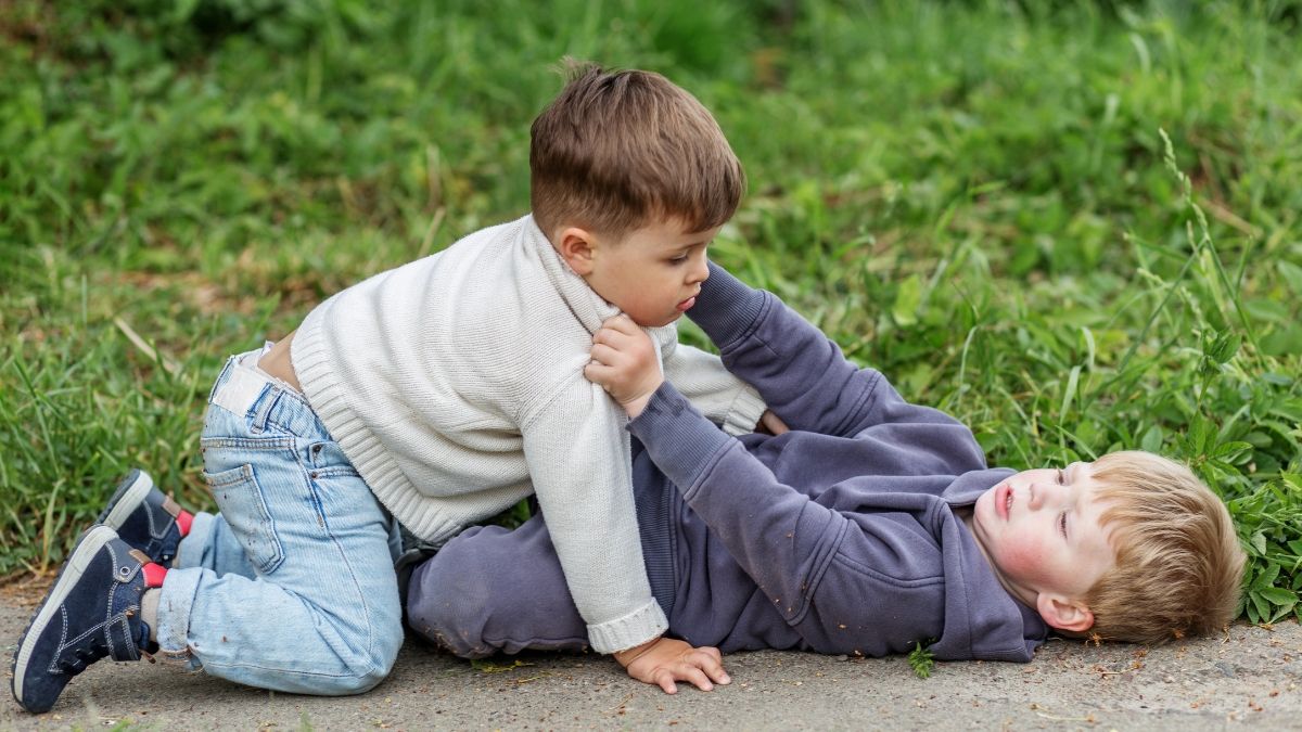 Dos niños peleando en el suelo