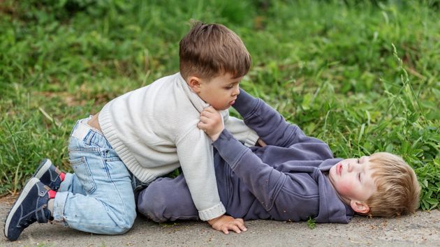 Dos niños peleando en el suelo