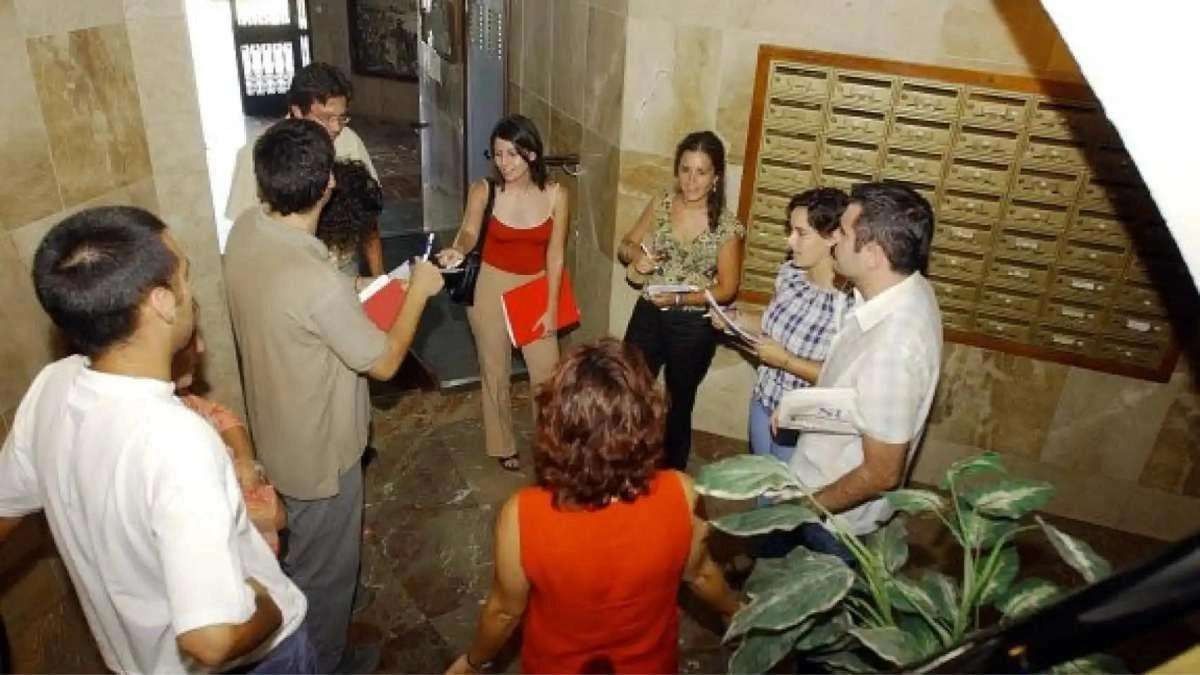 Vecinos reunidos en el portal de un edificio Vecinos reunidos en el portal de un edificio