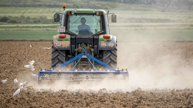 Un trabajador del campo subido en el tractor