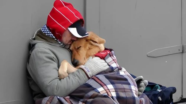 Un hombre abrazado a su perro