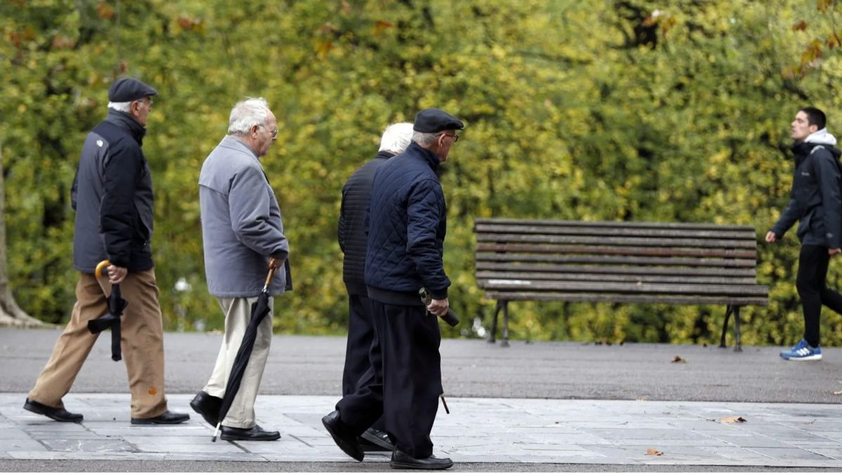 Varios jubilados pasean por el parque