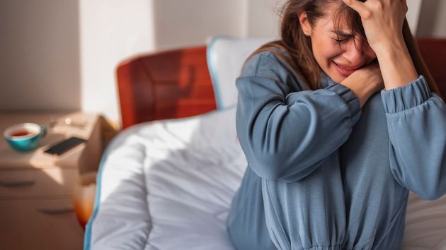 Joven llorando en su cama