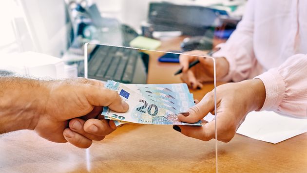 Una persona pagando con dinero en una administración